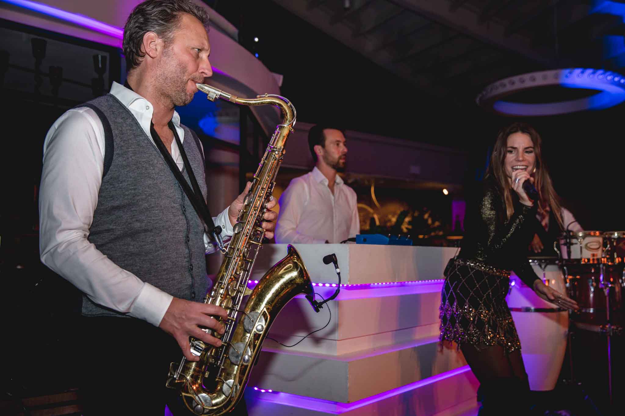 Man blazend op saxofoon met zingende vrouw op het podium - Timeless Events