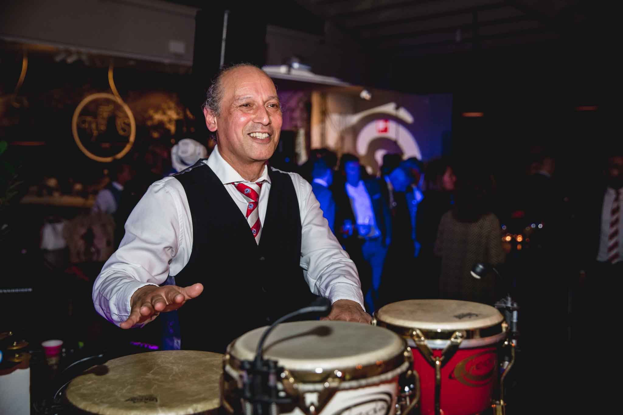 Man met een glimlach trommelend op een percussie instrument - Timeless Events