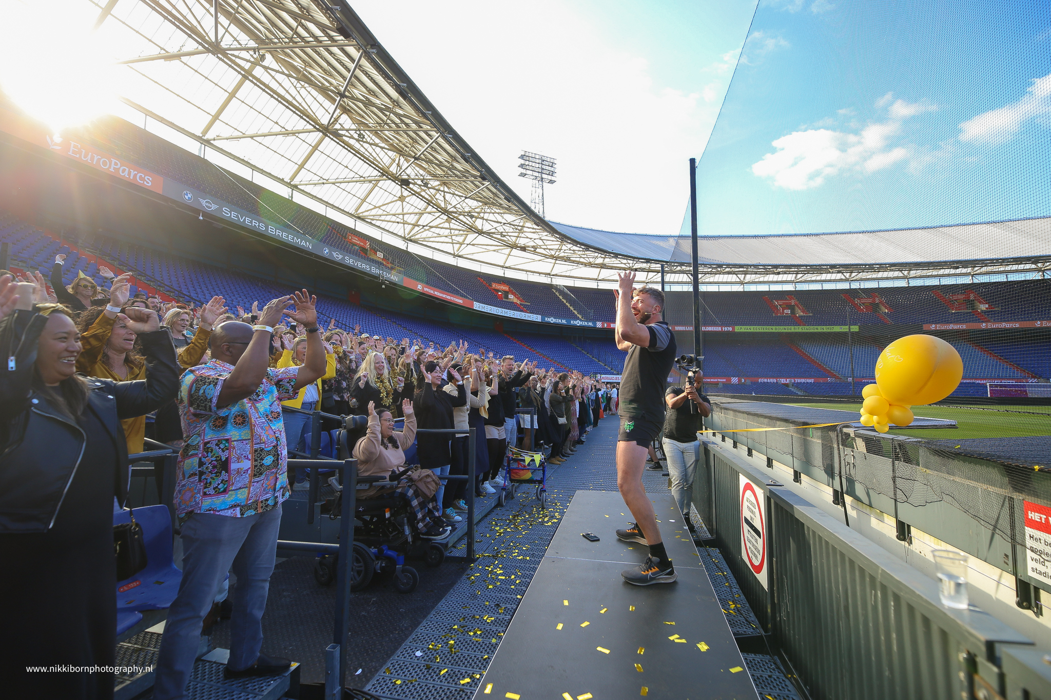 Publiek doet presentator na vanaf de tribune - Timeless Events