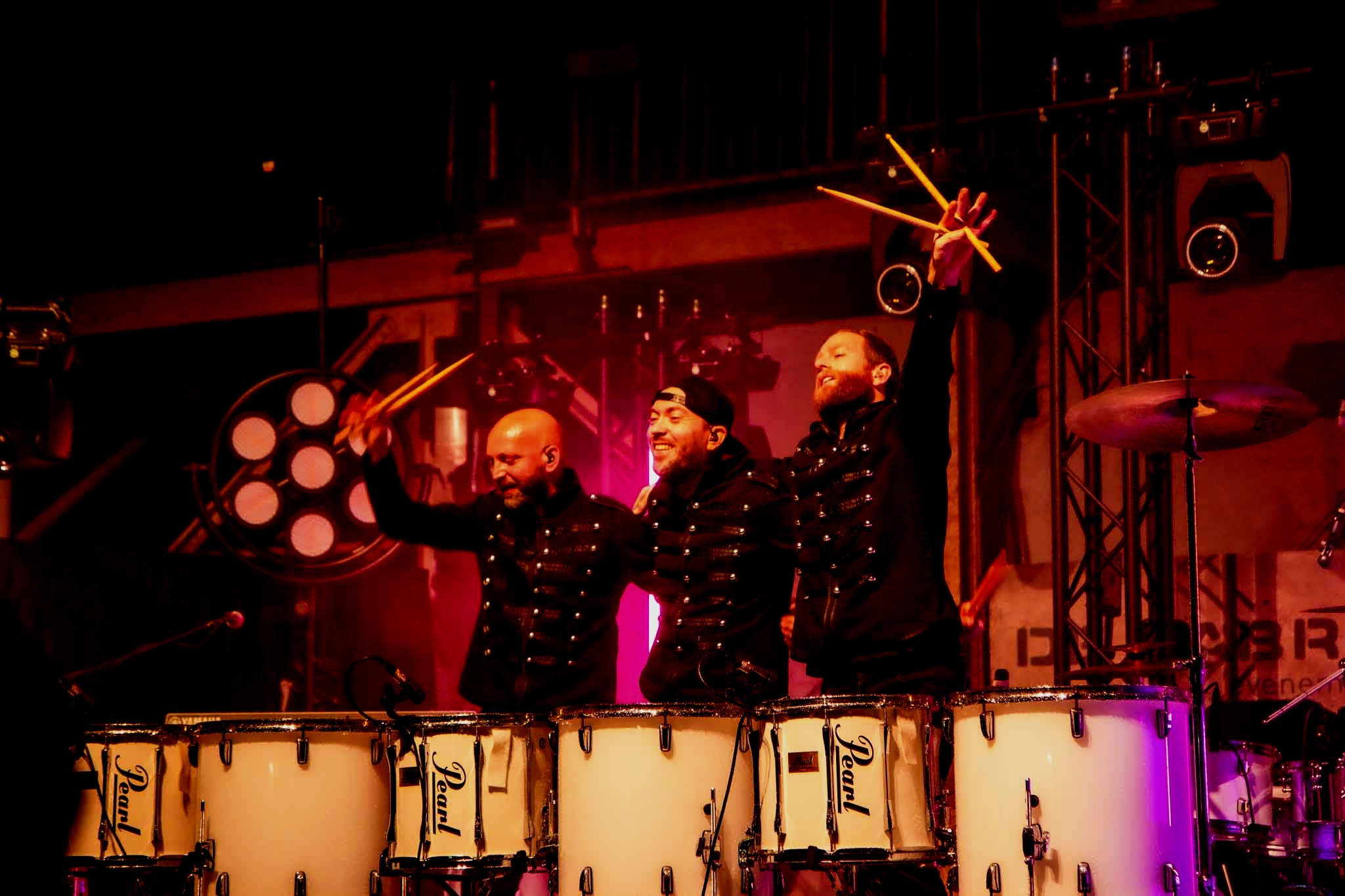 Drie drummers naast elkaar met hun armen in de lucht - Timeless Events