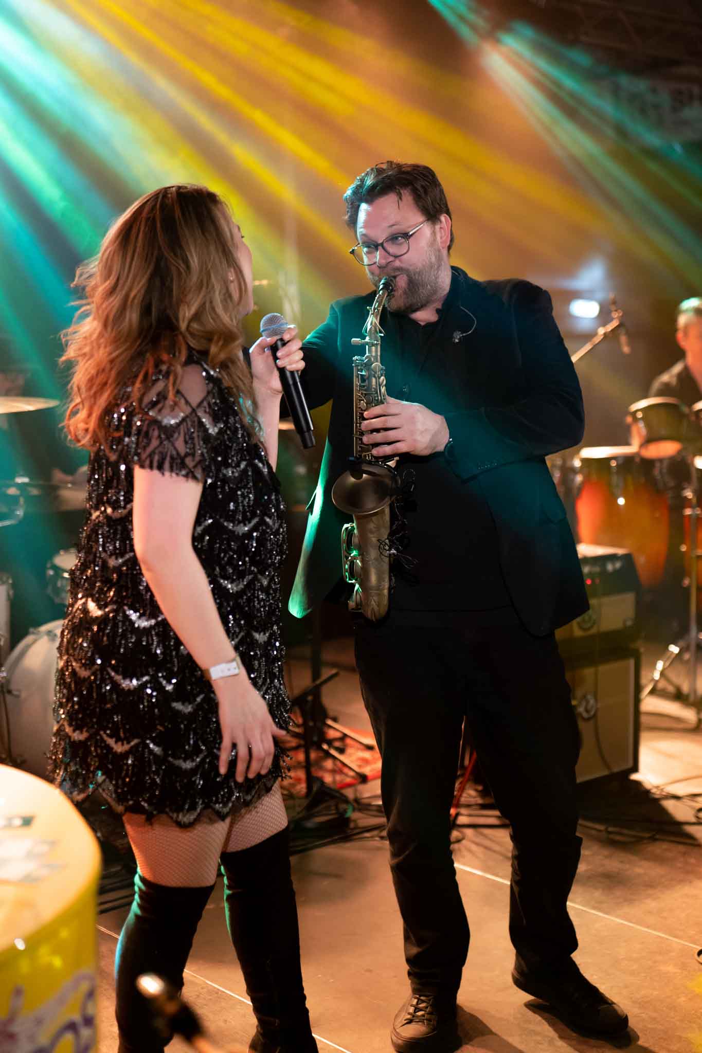 Man met saxofoon en vrouw met microfoon op het podium - Timeless Events