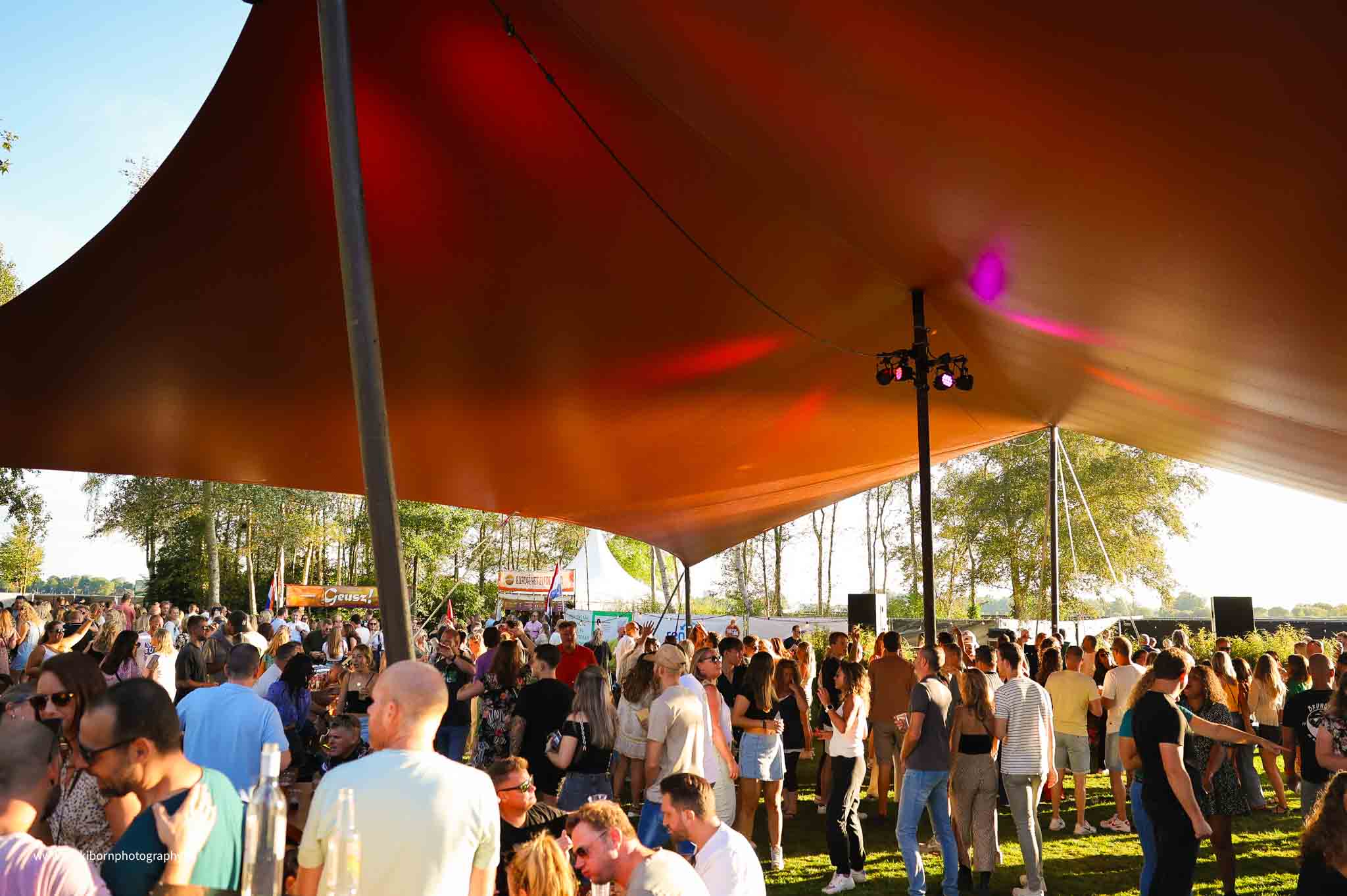 Publiek onder oranje partytent - Timeless Events