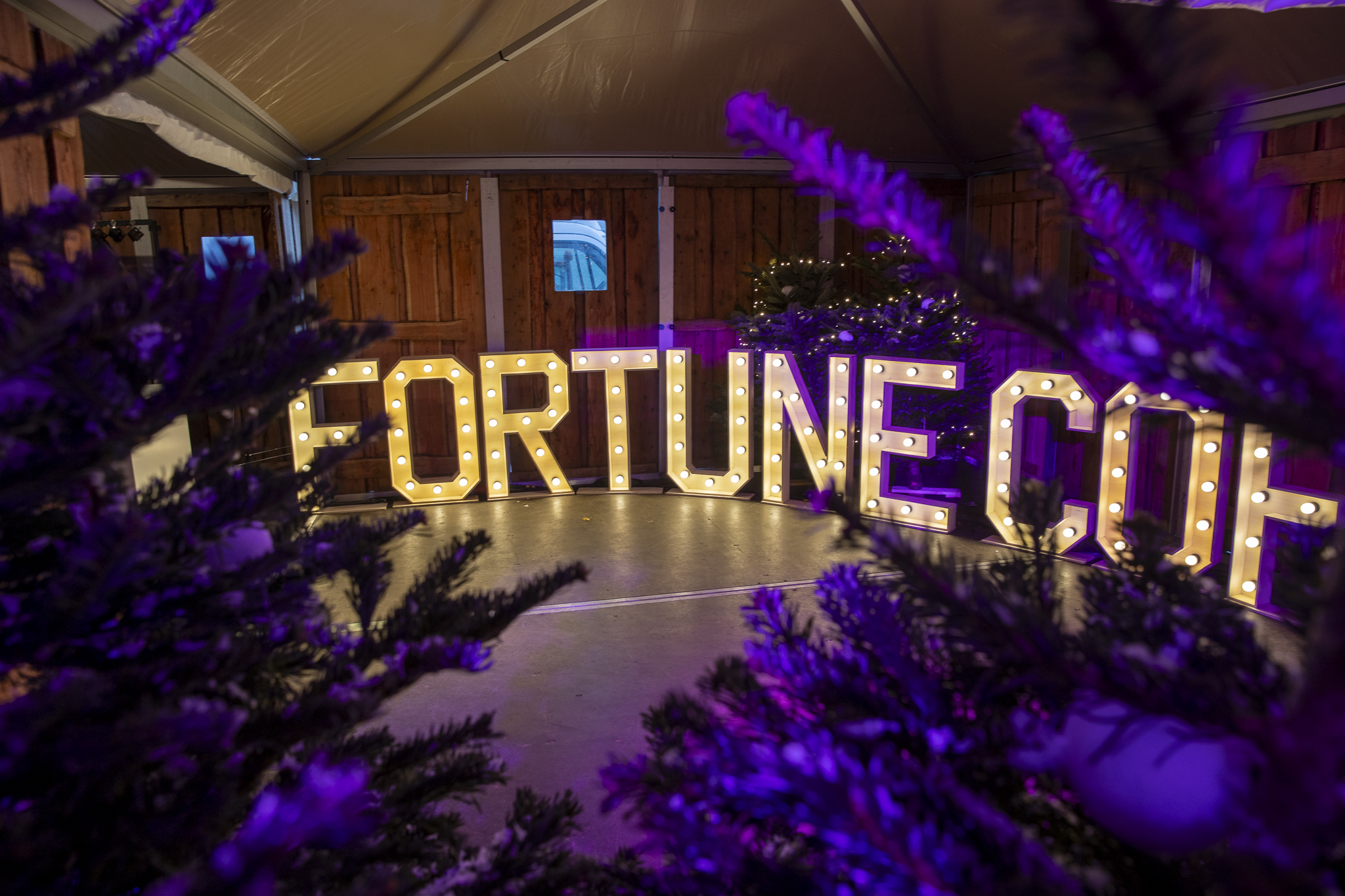Doorkijk van kerstbomen naar letterverlichting Fortune Coffee - Timeless Events