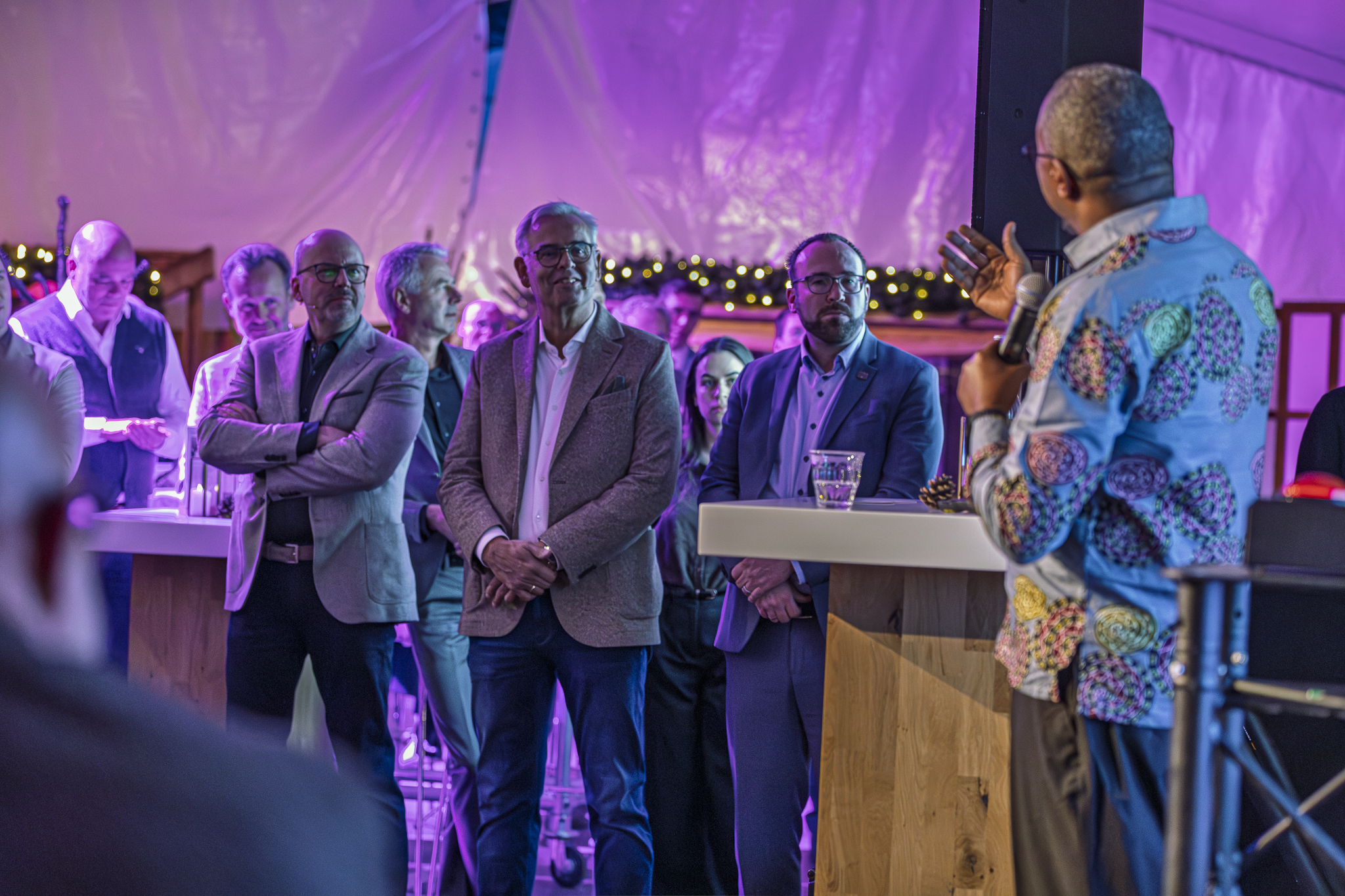 Speechende man met microfoon met mannen op de achtergrond - Timeless Events