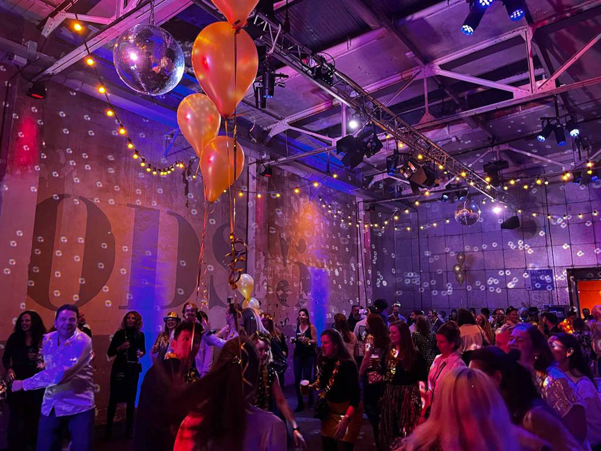 Dansende mensen in een versierde loods - Timeless Events