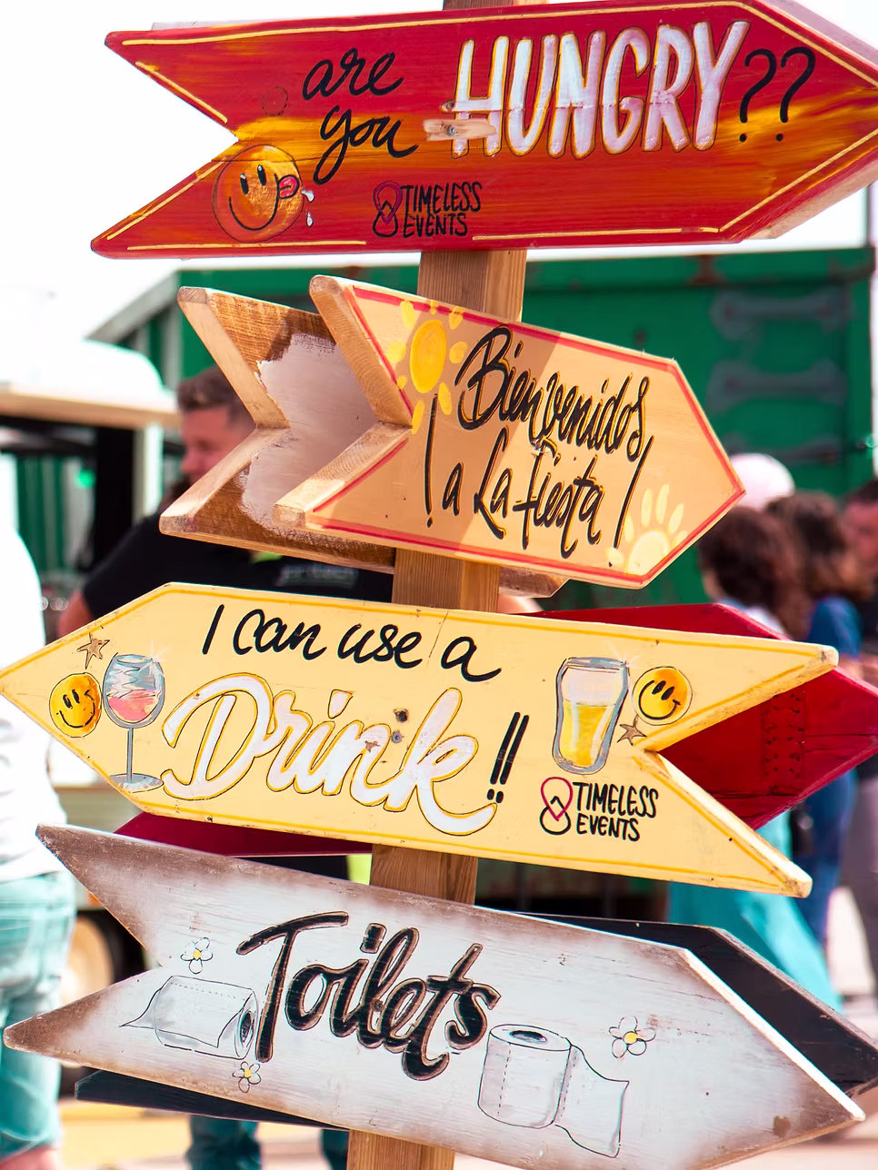 Bord met pijlen richting eten, feest, bar en toiletten