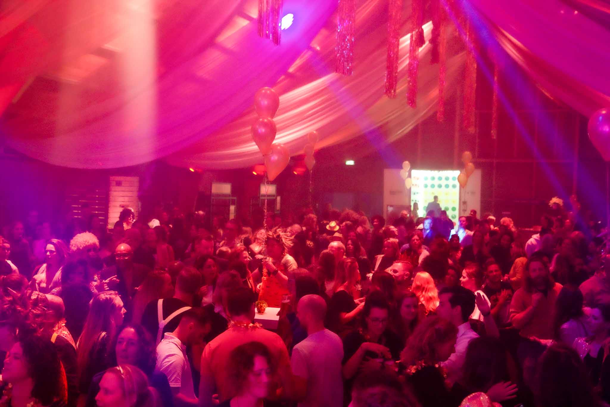 Volle versierde zaal met roze verlichting - Timeless Events