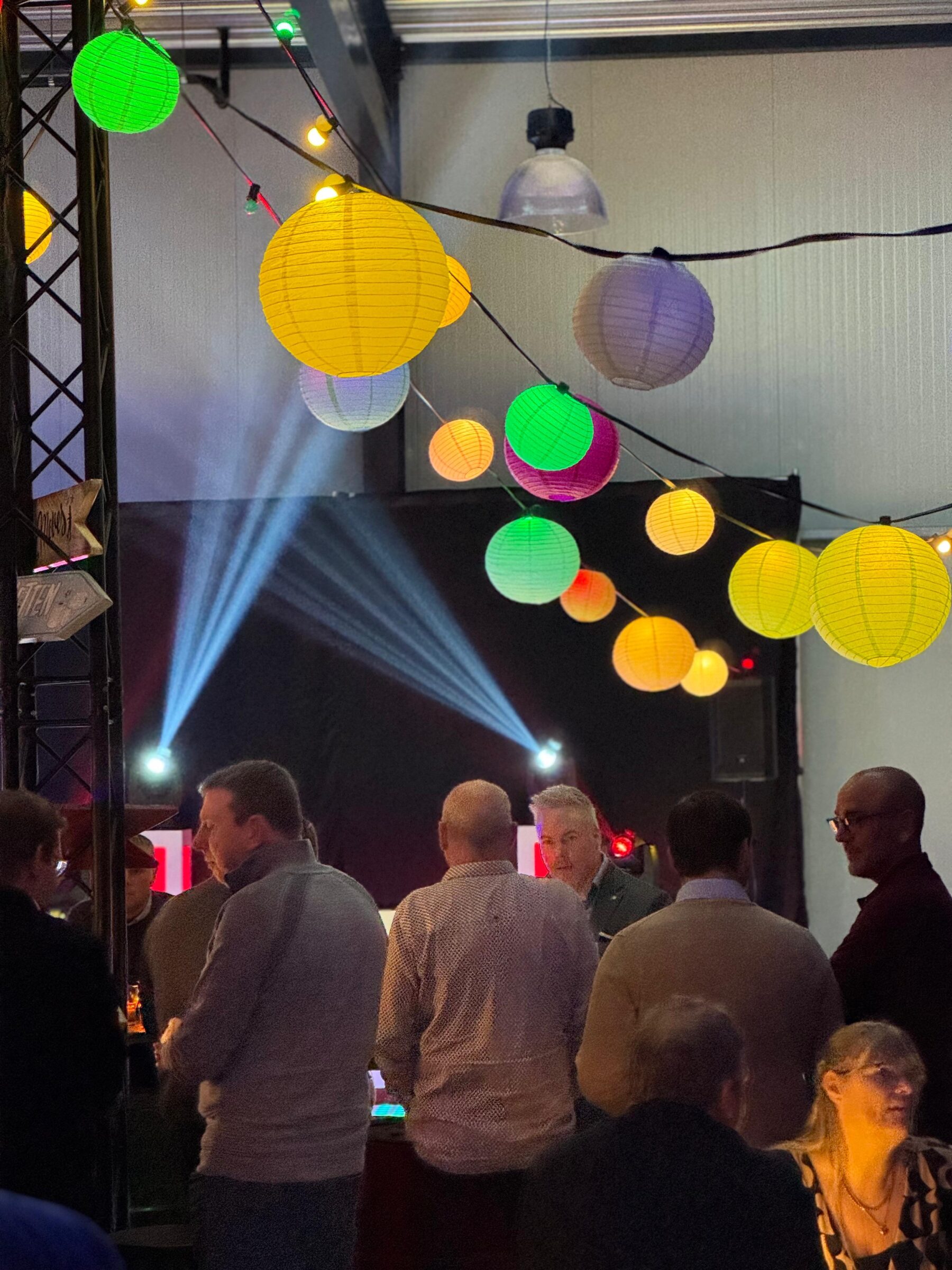 Publiek in de hangaar met gekleurde lampionnen - Timeless Events