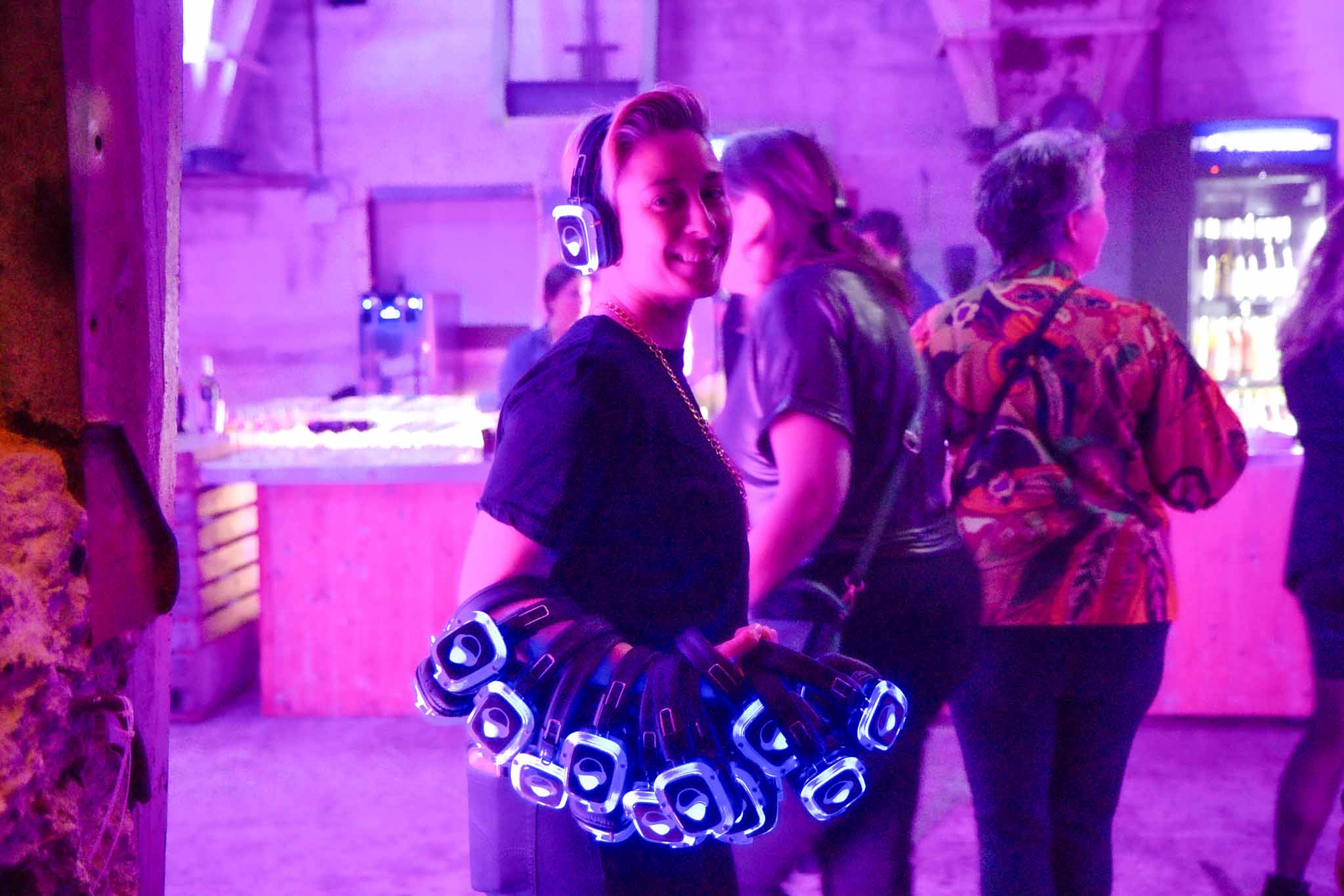 Vrouw met koptelefoon op en veel koptelefoons om haar arm - Timeless Events