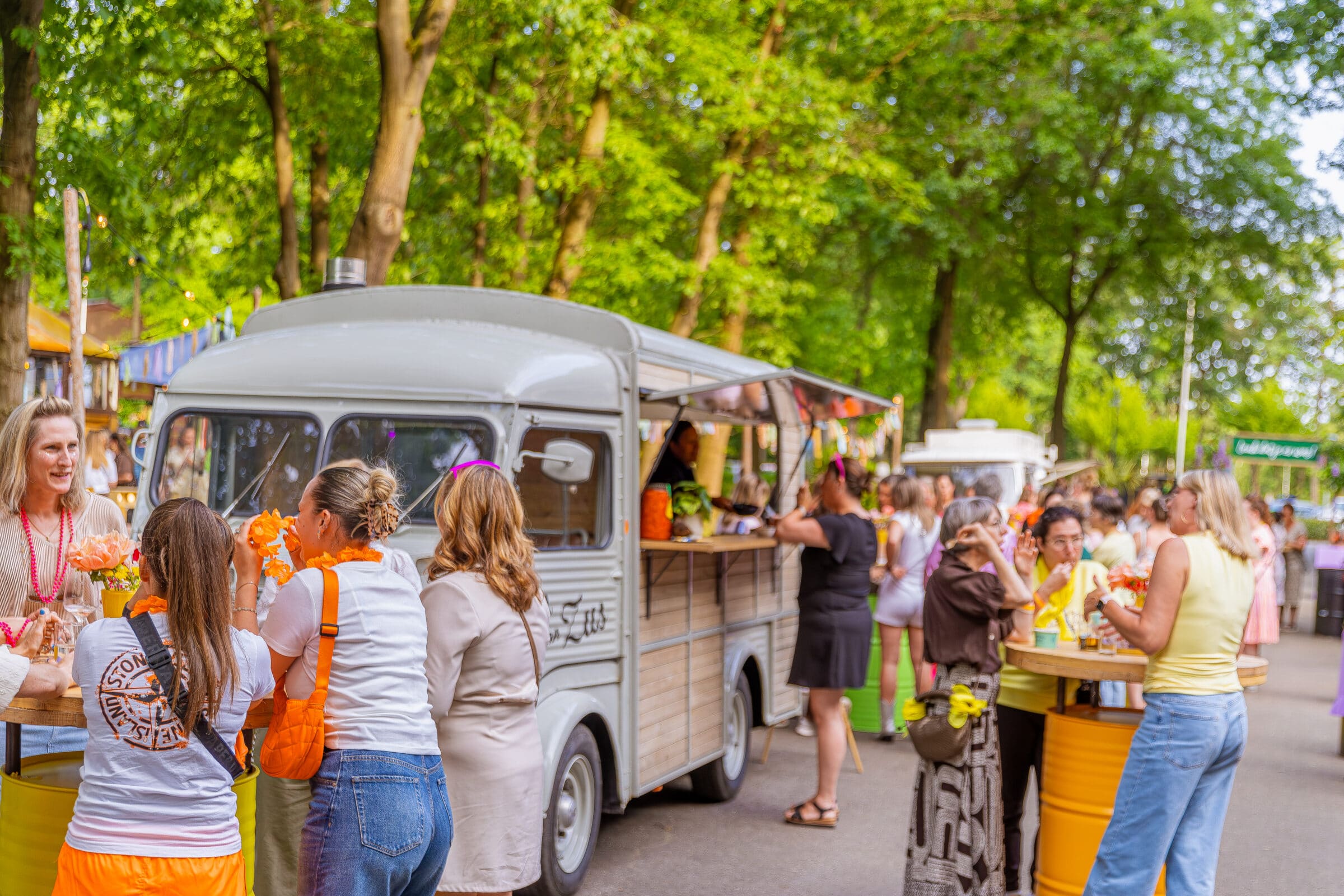 grijze foodtruck met mensen eromheen