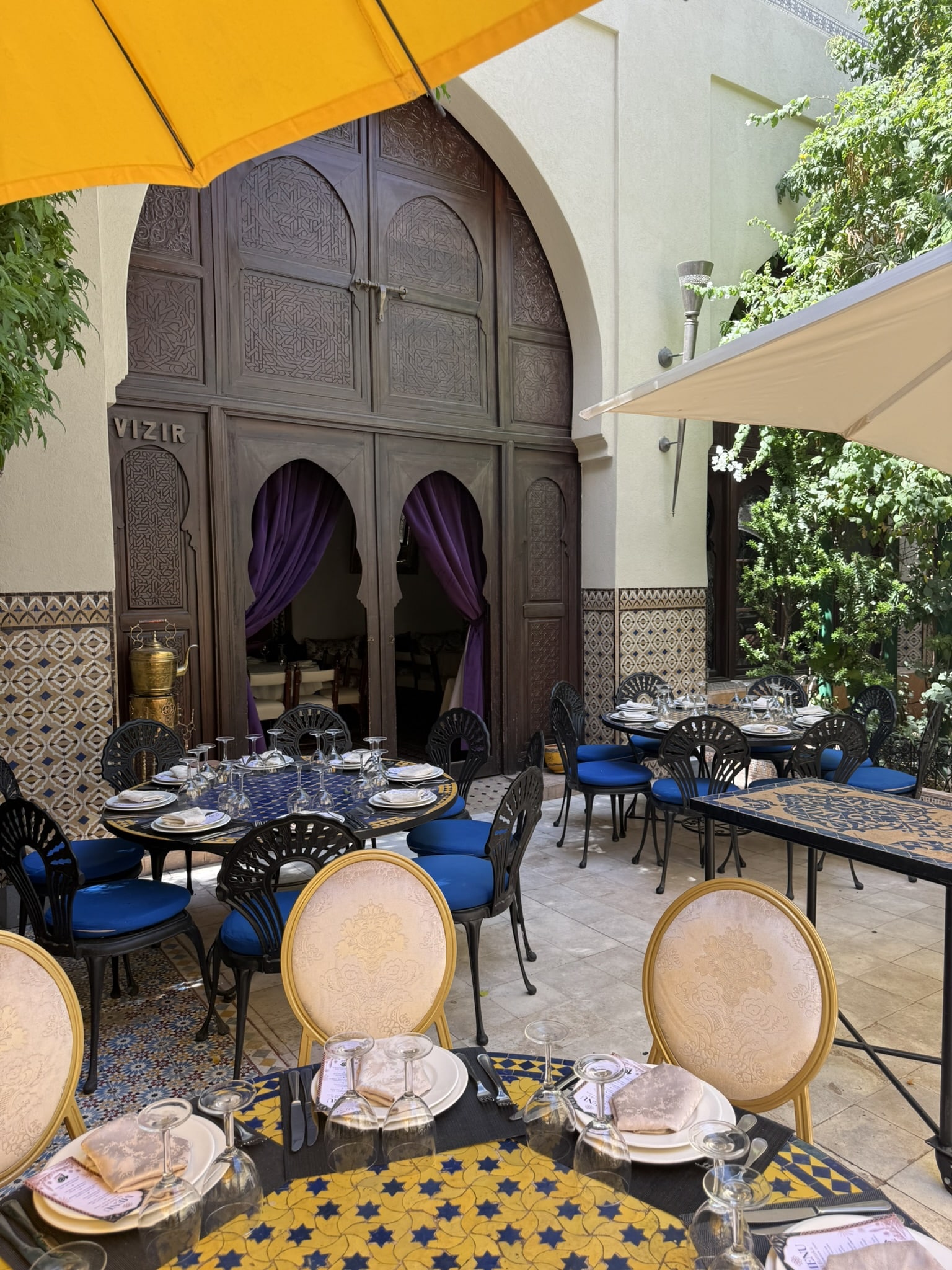 buitenterras marokaans restaurant met gedekte ronde tafels